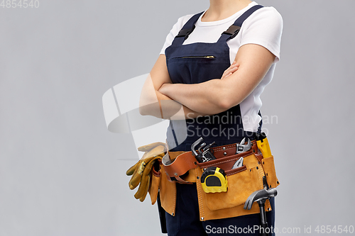 Image of woman or builder with working tools on belt