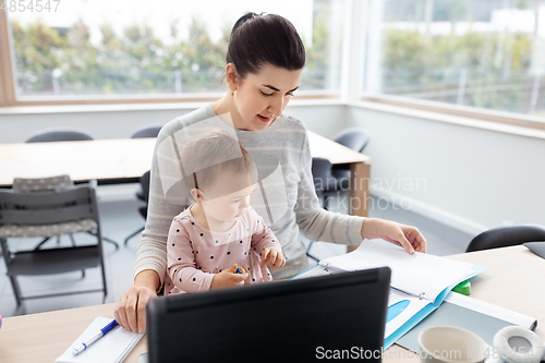 Image of mother with baby working at home office
