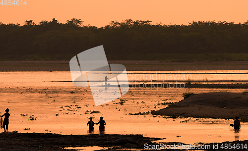 Image of Asian women fishing in the river, silhouette at sunset