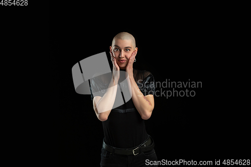 Image of Monochrome portrait of young caucasian bald woman on black background