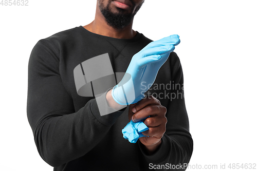 Image of How coronavirus changed our lives. Young man wearing protective gloves on white background
