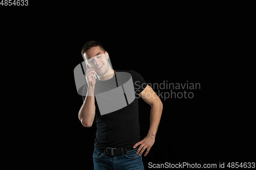 Image of Monochrome portrait of young caucasian man on black studio background