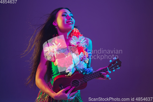 Image of Fabulous Cinco de Mayo female dancer on purple studio background in neon light