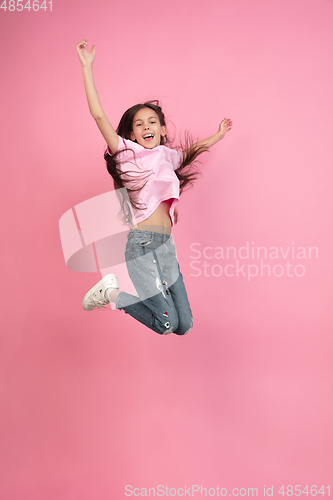 Image of Caucasian little girl portrait isolated on pink studio background, emotions concept