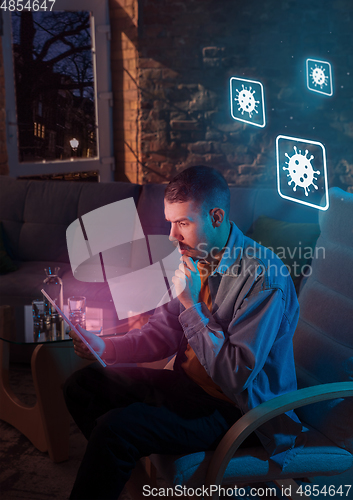 Image of Shocked, upset and sad man using gadgets to get information of coronavirus pandemic spread