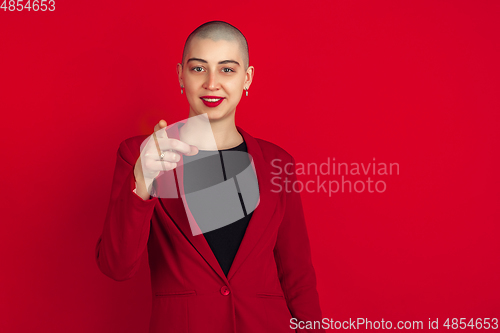 Image of Portrait of young caucasian bald woman on red background