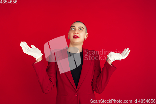 Image of Portrait of young caucasian bald woman on red background