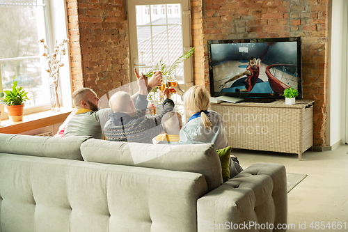 Image of Excited family watching basketball, sport match at home