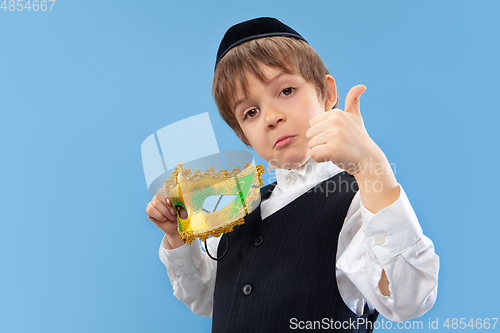 Image of Portrait of a young orthodox jewish boy isolated on blue studio background, meeting the Passover