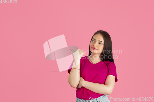 Image of Monochrome portrait of young caucasian brunette woman on pink background
