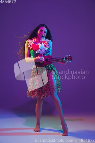 Image of Fabulous Cinco de Mayo female dancer on purple studio background in neon light