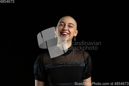 Image of Monochrome portrait of young caucasian bald woman on black background