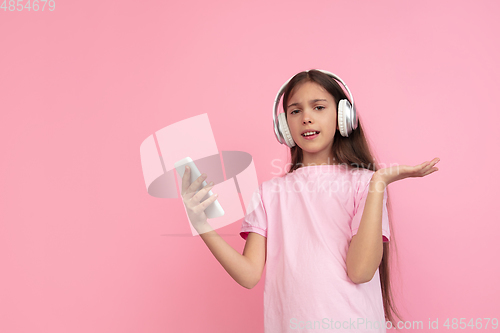 Image of Caucasian little girl portrait isolated on pink studio background, emotions concept