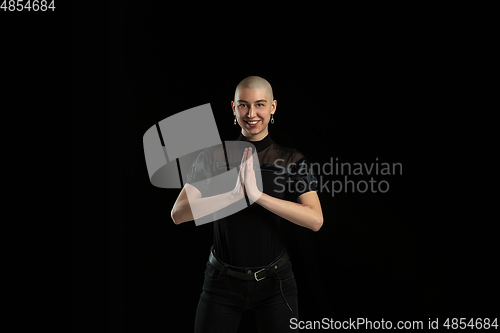 Image of Monochrome portrait of young caucasian bald woman on black background