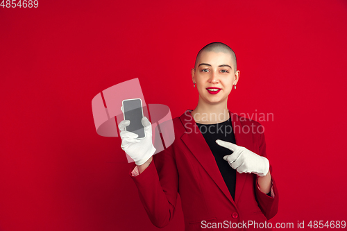 Image of Portrait of young caucasian bald woman on red background