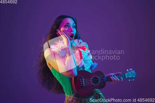 Image of Fabulous Cinco de Mayo female dancer on purple studio background in neon light