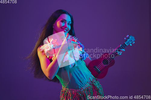 Image of Fabulous Cinco de Mayo female dancer on purple studio background in neon light