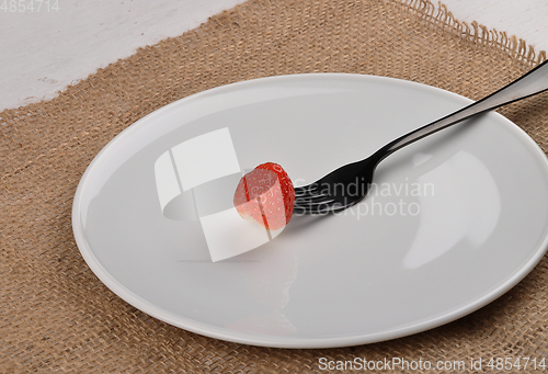 Image of Strawberry on fork and plate