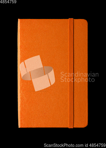 Image of Orange closed notebook isolated on black