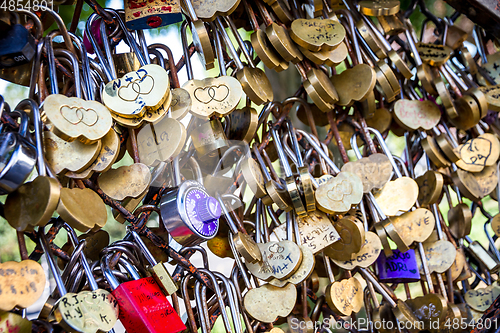 Image of Padlocks symbols of love hanging on a fence