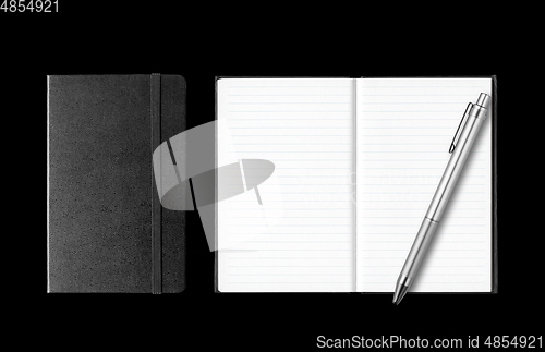 Image of Closed and open notebooks with pen isolated on black