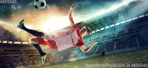 Image of Male football or soccer player at stadium - motion, action, activity concept