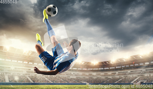 Image of Male football or soccer player at stadium - motion, action, activity concept