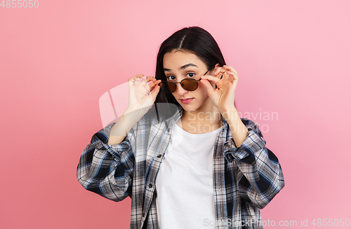 Image of Caucasian woman\'s portrait isolated on coral pink studio background with copyspace