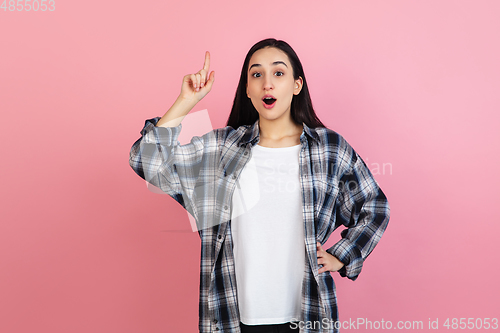 Image of Caucasian woman\'s portrait isolated on coral pink studio background with copyspace