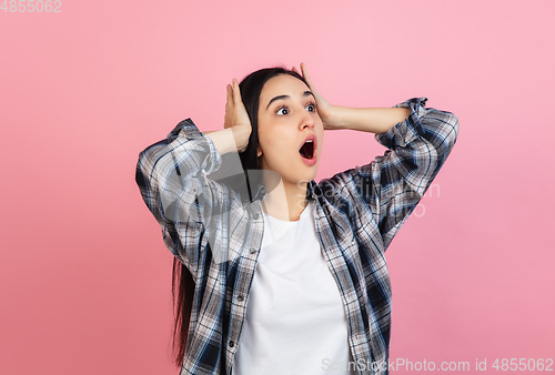 Image of Caucasian woman\'s portrait isolated on coral pink studio background with copyspace