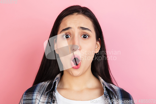 Image of Caucasian woman\'s portrait isolated on coral pink studio background with copyspace