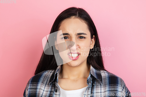Image of Caucasian woman\'s portrait isolated on coral pink studio background with copyspace