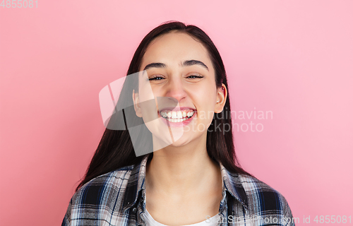 Image of Caucasian woman\'s portrait isolated on coral pink studio background with copyspace