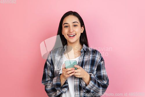 Image of Caucasian woman\'s portrait isolated on coral pink studio background with copyspace