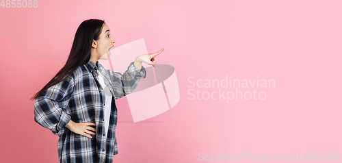 Image of Caucasian woman\'s portrait isolated on coral pink studio background with copyspace