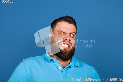 Image of Caucasian man\'s portrait isolated on blue studio background with copyspace