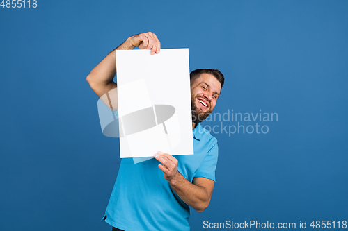 Image of Caucasian man\'s portrait isolated on blue studio background with copyspace