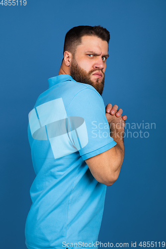 Image of Caucasian man\'s portrait isolated on blue studio background with copyspace