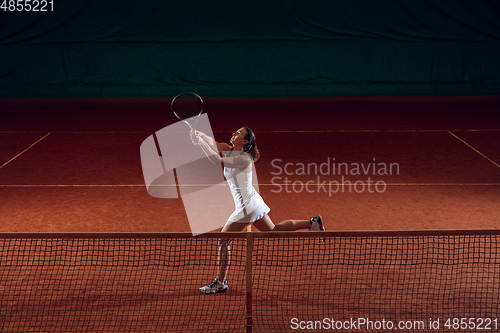 Image of Young caucasian professional sportswoman playing tennis on sport court background