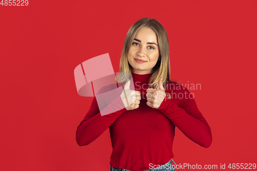 Image of Monochrome portrait of young caucasian blonde woman on red background