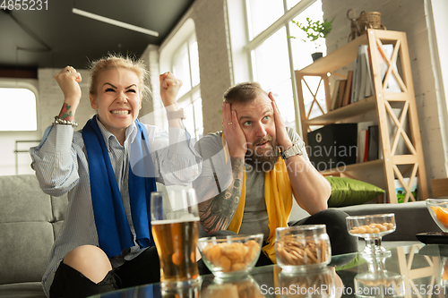 Image of Excited family watching football, sport match at home, beautiful couple