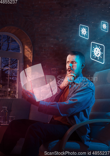 Image of Shocked, upset and sad man using gadgets to get information of coronavirus pandemic spread