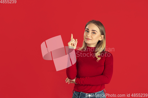 Image of Monochrome portrait of young caucasian blonde woman on red background