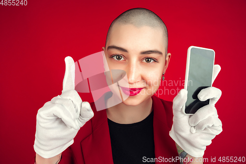 Image of Portrait of young caucasian bald woman on red background