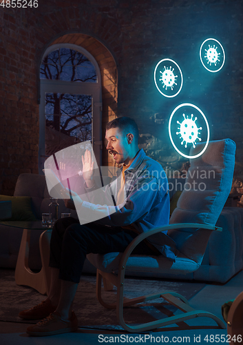 Image of Shocked, upset and sad man using gadgets to get information of coronavirus pandemic spread