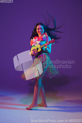 Image of Fabulous Cinco de Mayo female dancer on purple studio background in neon light