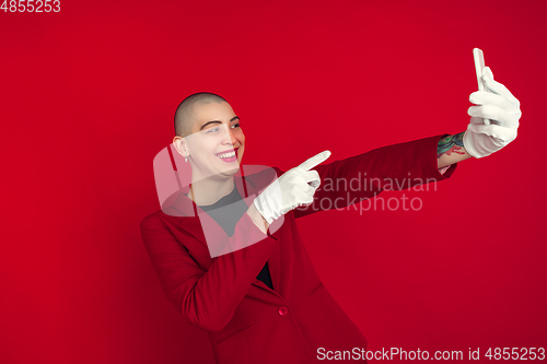 Image of Portrait of young caucasian bald woman on red background