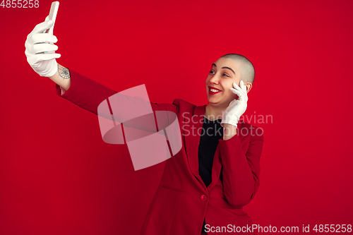 Image of Portrait of young caucasian bald woman on red background