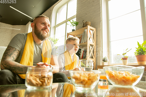 Image of Excited family watching football, sport match at home, father and son
