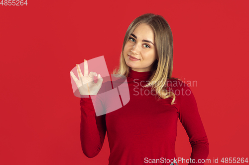 Image of Monochrome portrait of young caucasian blonde woman on red background